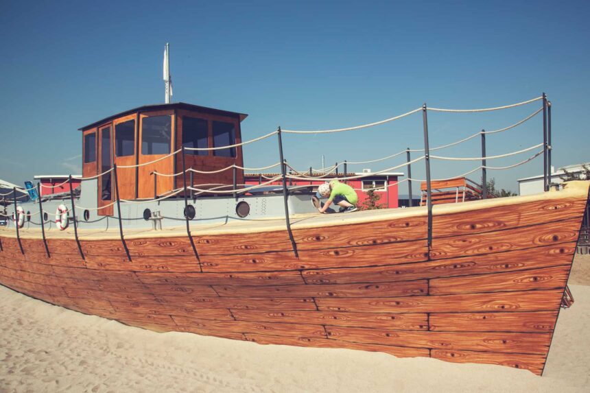 Ein Holzboot im Sand.
